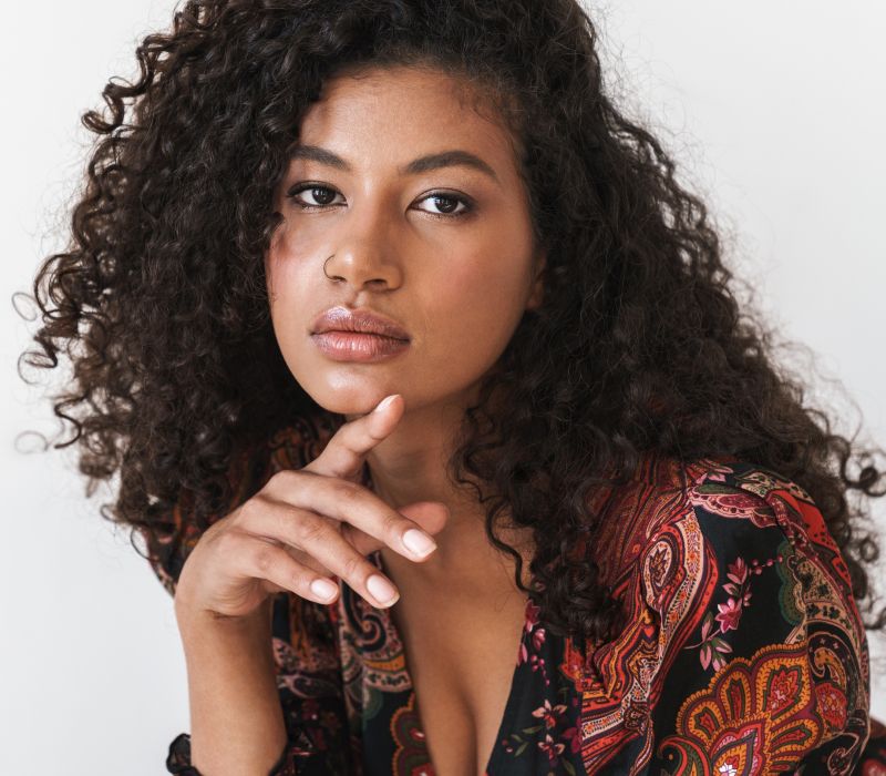 Person with curly hair, thoughtful expression, colorful clothing